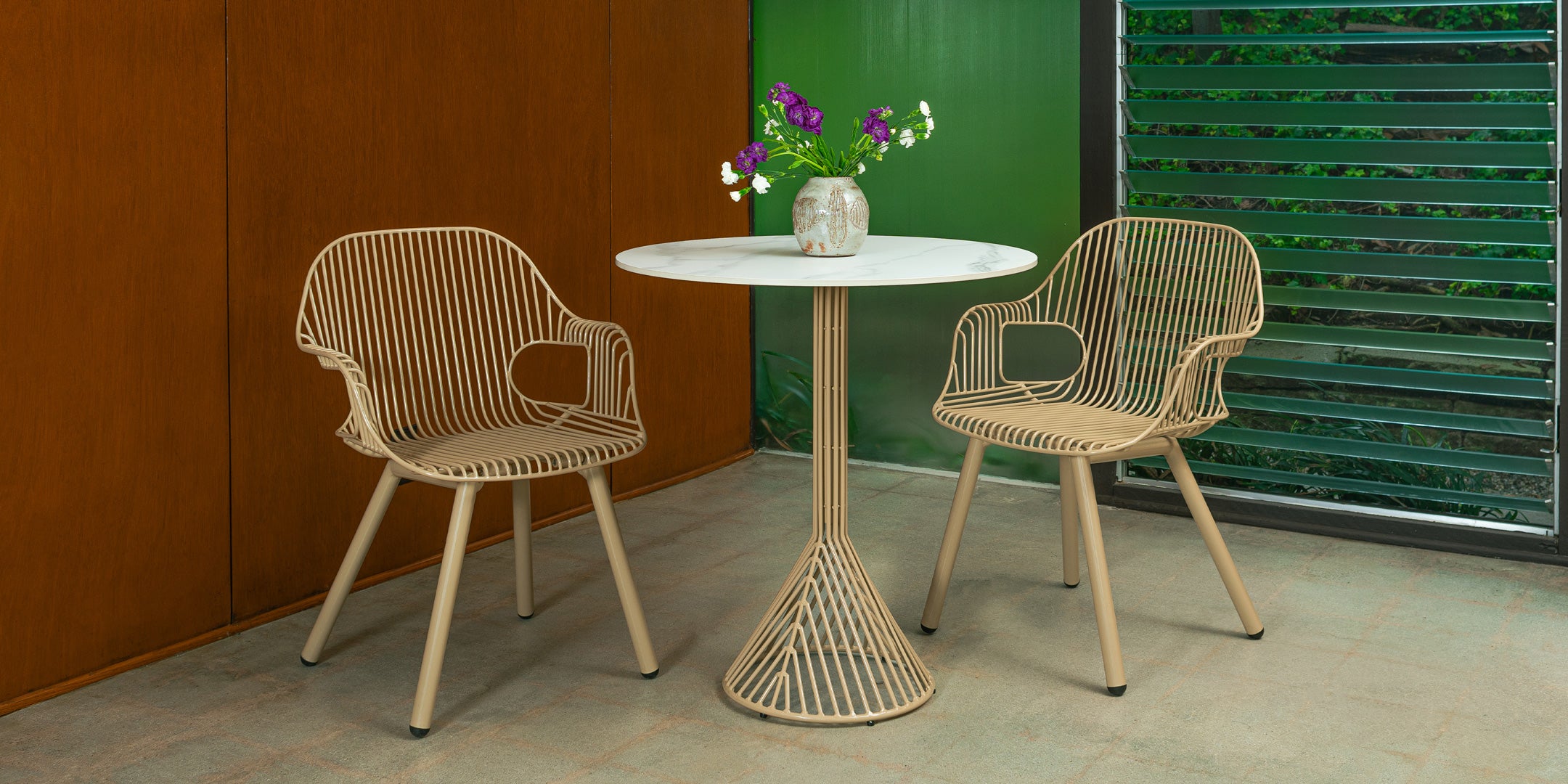 30" Bistro Table shown in Tan with White Ceramic Stone Top. Pictured with two Rita Arm Chairs in Tan in interior space.