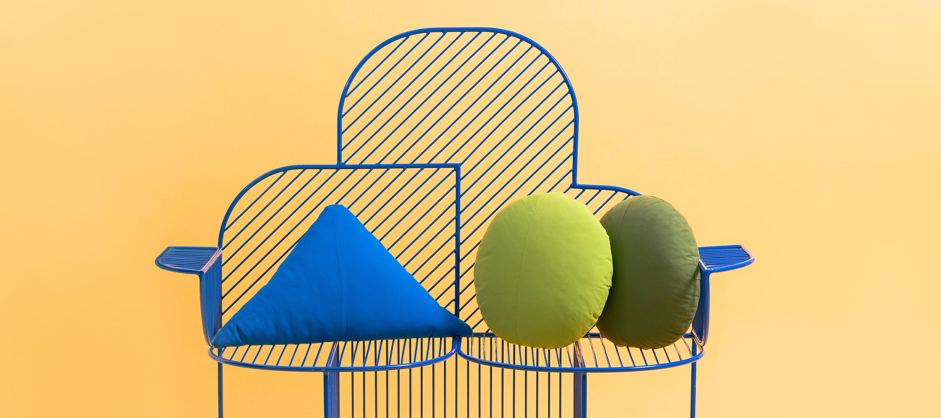 Cloud Bench shown in Electric Blue with Throw Pillows and a Triangle Throw Pillow. Pictured in front of yellow background