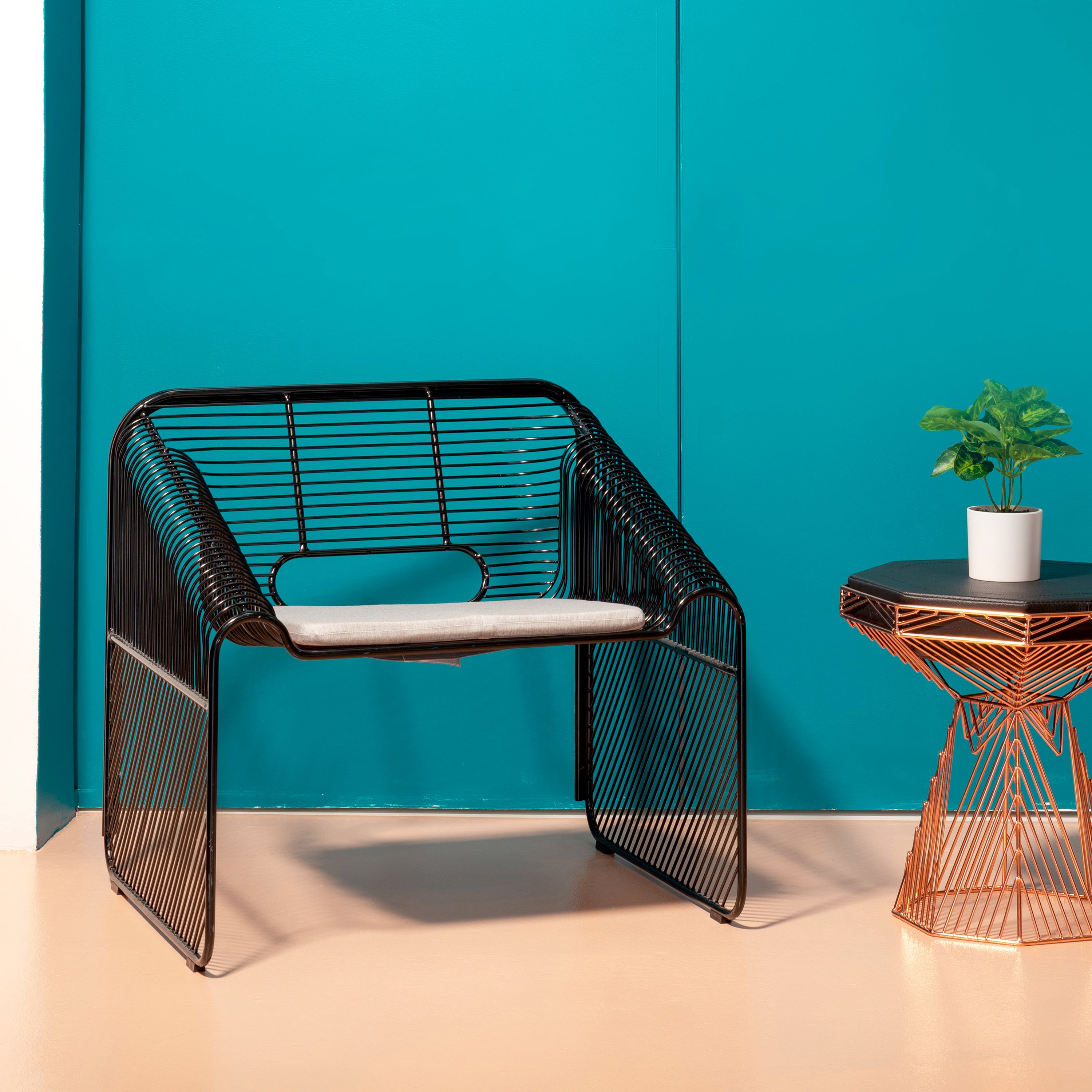 Hot Seat shown in Black with Granite Sunbrella Pad next to a Copper Switch Stool\Table