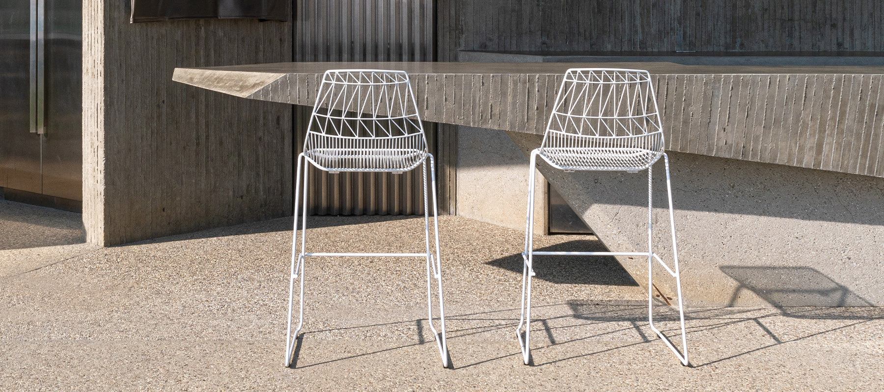Stacking Lucy Barstools shown in White. Pictured in outdoor bar top area in Hollywood Hills home