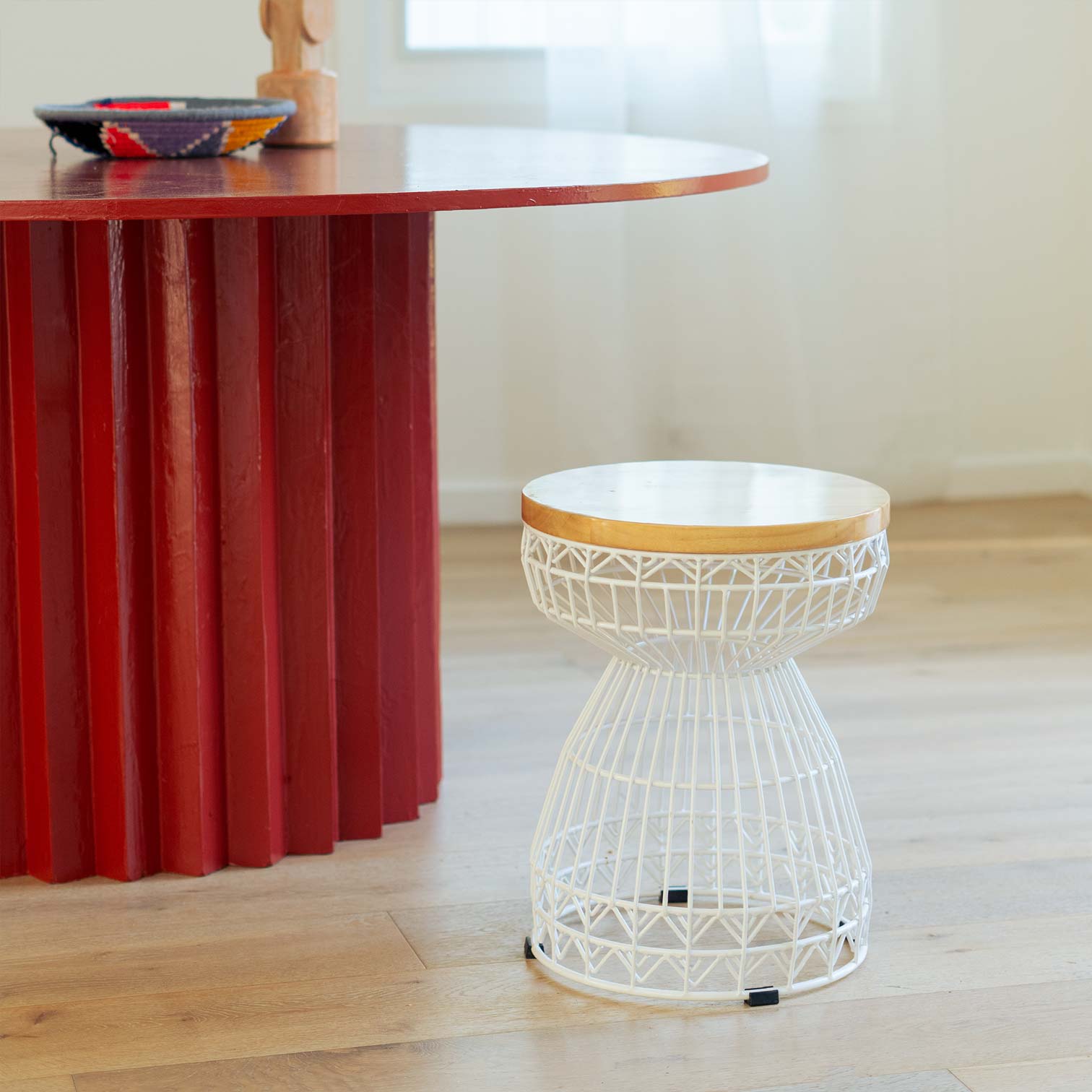 Sweet Stool White shown in White near a large red dining table.
