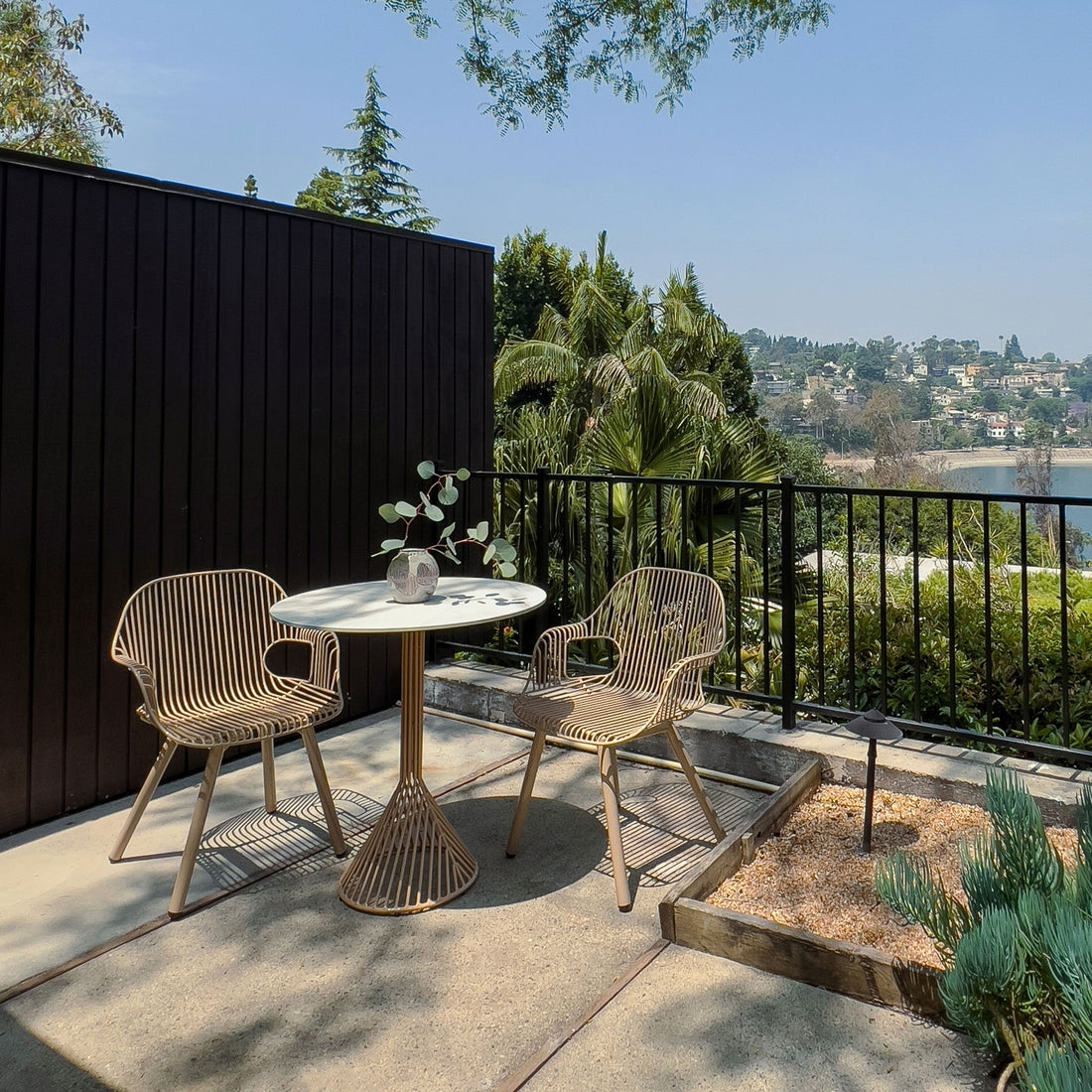 Rita Arm Dining Chairs paired with the 30" Bistro Table on a balcony. Powder coated in our new color Tan and outdoor ready.