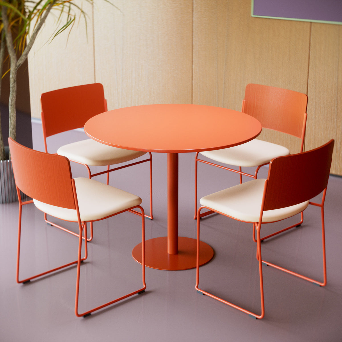 A round orange dining table with four matching orange and cream chairs, arranged in a modern indoor setting with a light wood paneled wall and gray floor.
