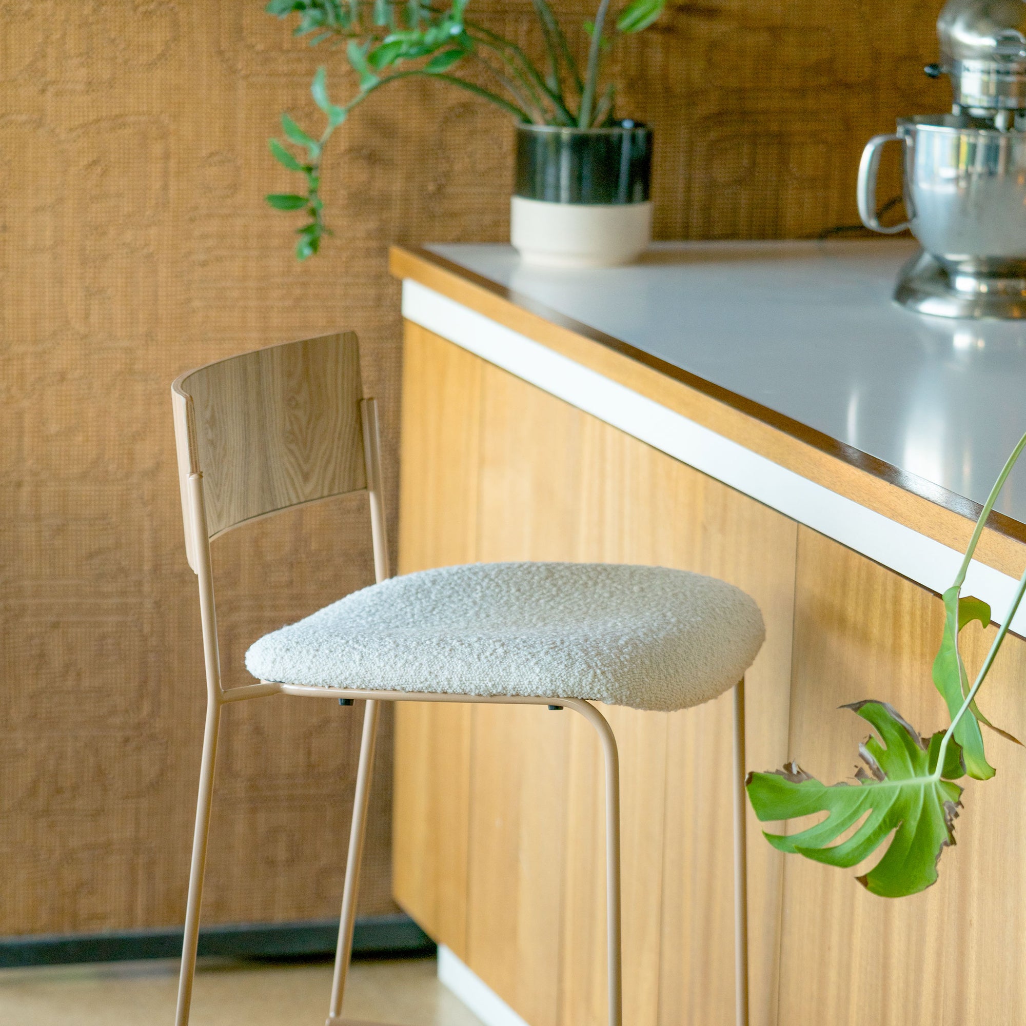 Bend Goods Diane modern dining chair featuring a tan metal frame, wood backrest, and cream boucle seat cushion.
