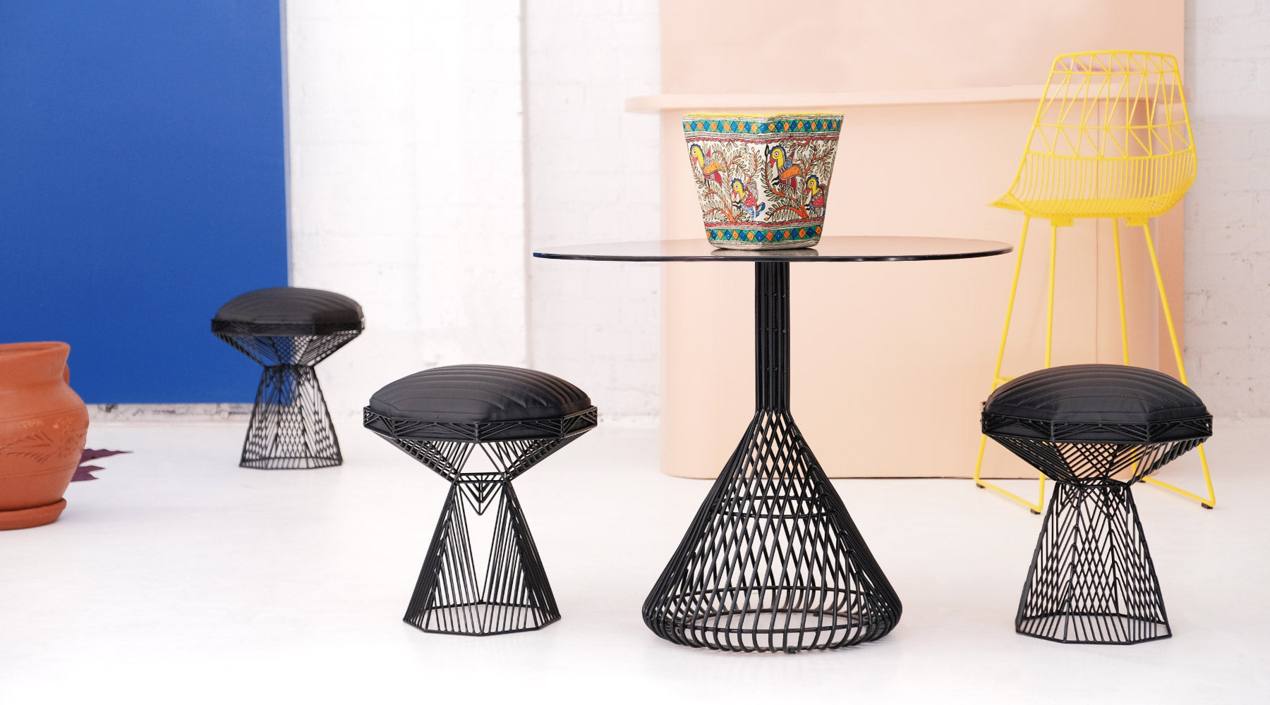 Bistro Table shown in Black. Pictured with Switch Stools in Black