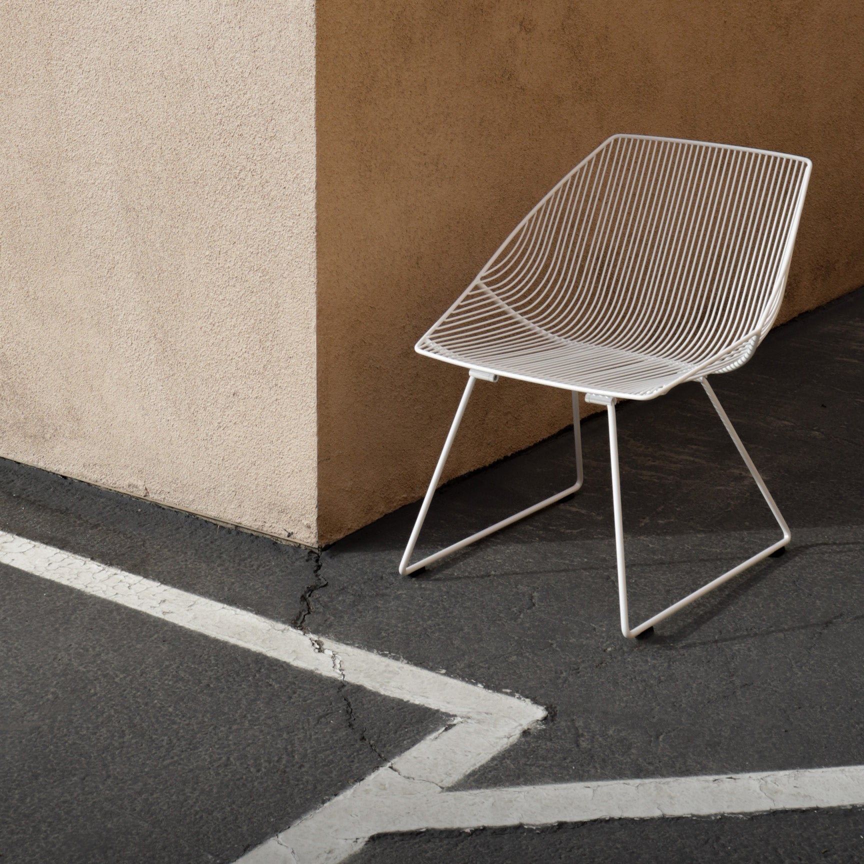 Bunny Lounge Chair shown in White. Pictured near tan wall