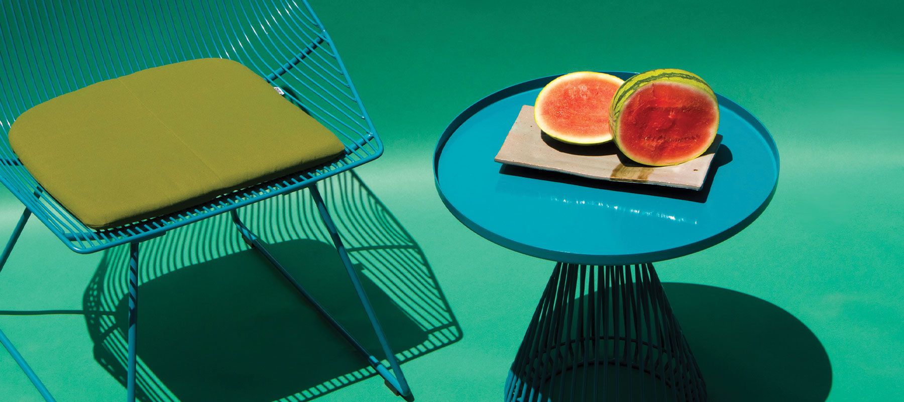 Cono Table shown in Peacock Blue. Pictured next to the Bunny Lounge Chair