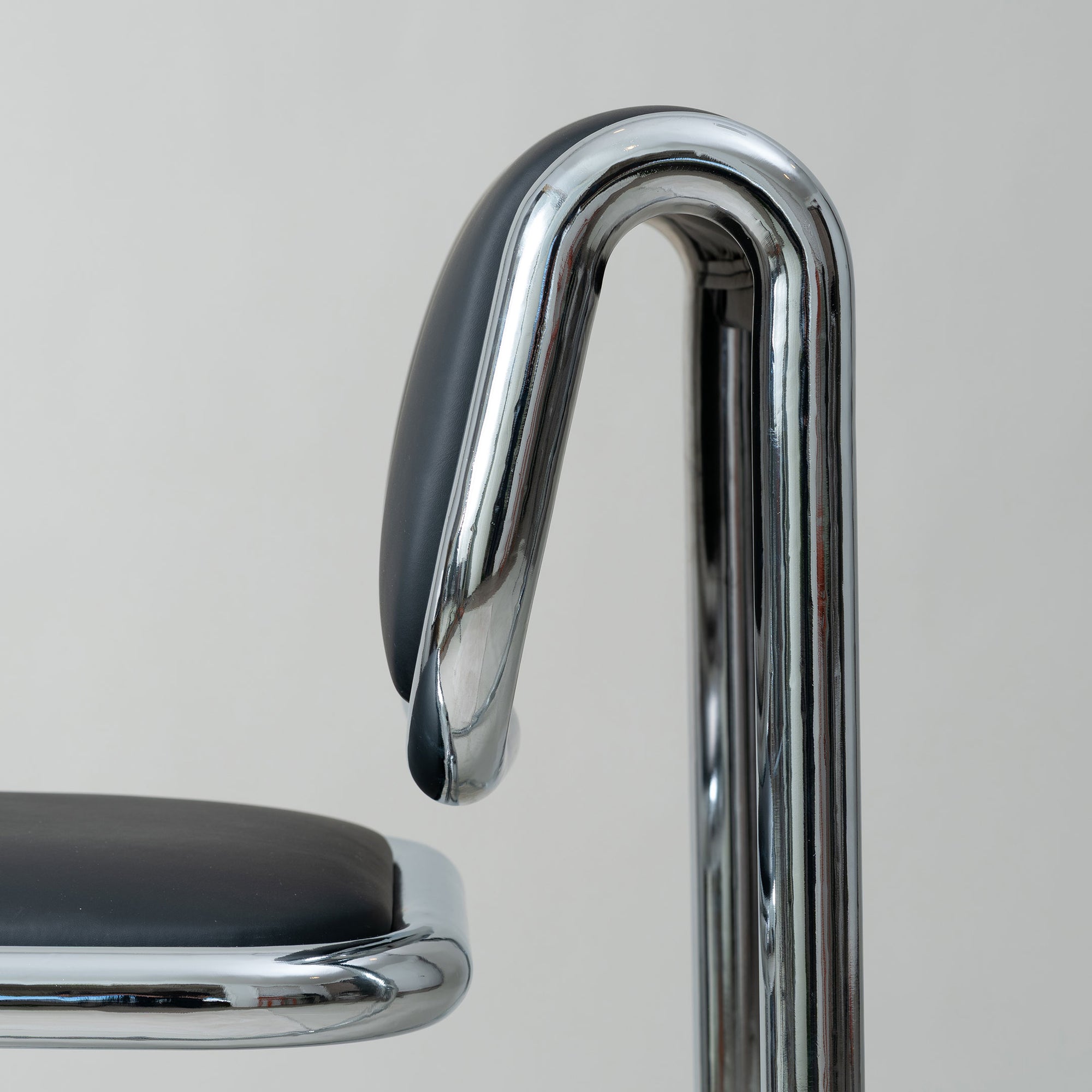 Close-up of a chrome tube chair back rest cantilever on a plain background, Bend Goods.